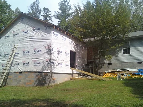 Tyvek wrapped gable on a new room addition beside an existing home in State Center
